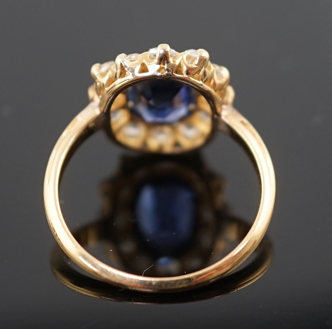 A gold, sapphire and old round cut diamond set oval cluster ring